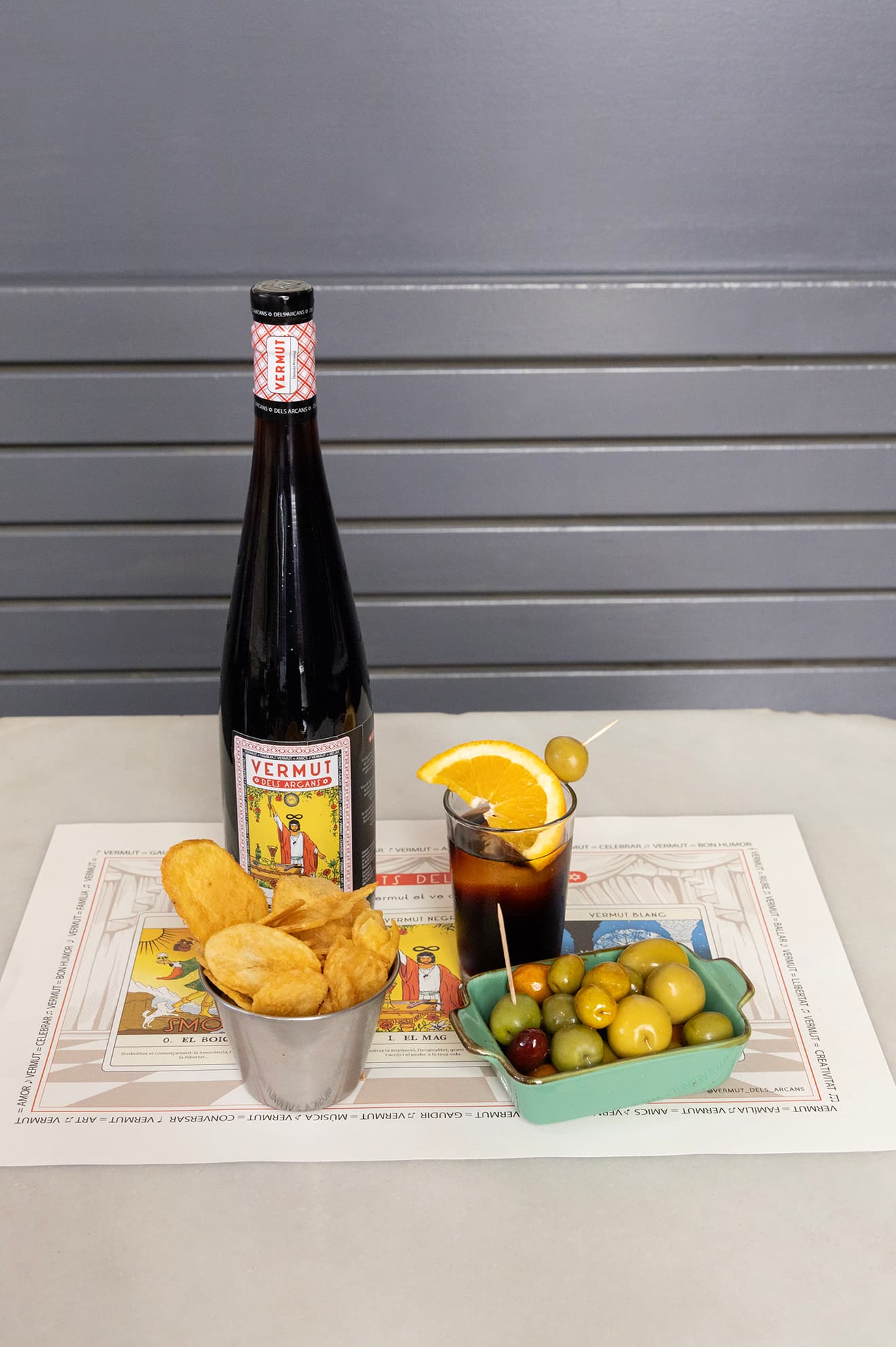 El Mag servit amb patates, olives i copa sobre el mantell dels Arcans