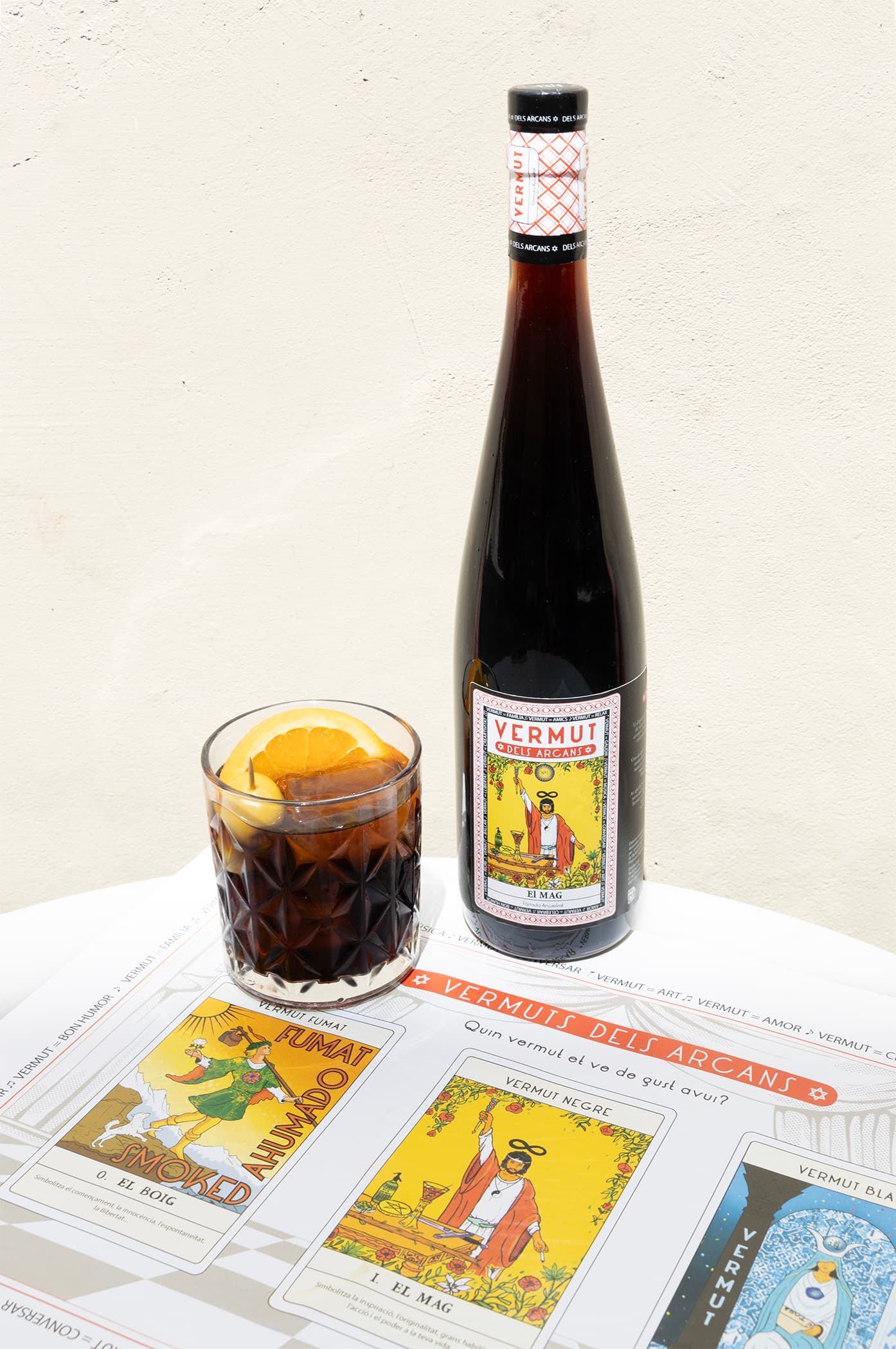 Ampolla El Mag amb copa de vermut i les cartes dels Arcans sobre la taula